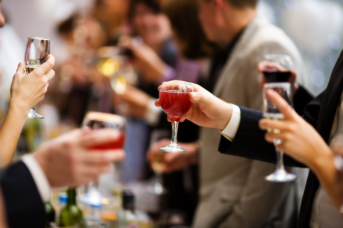 people cheering with drinks at a holiday party