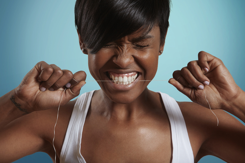 woman trying to gnaw through a dental floss