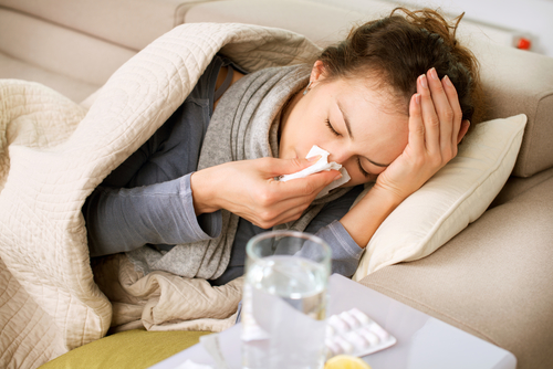 sick woman blowing her nose