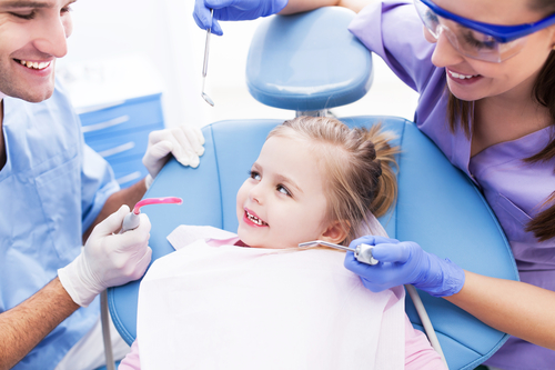 Child smiling at dentist during first dental exam