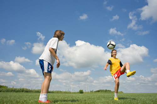 two teenagers playing soccer