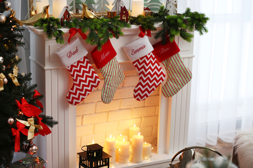 colorful christmas stockings hanging over fireplace with healthy treats inside
