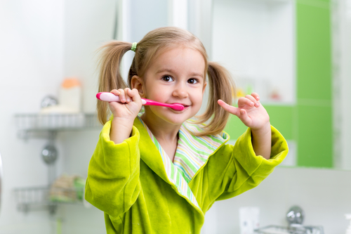 girl brushing teeth in bathroom
