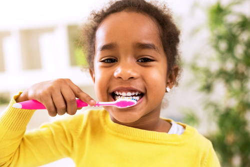 happy young girl brushing her teeth