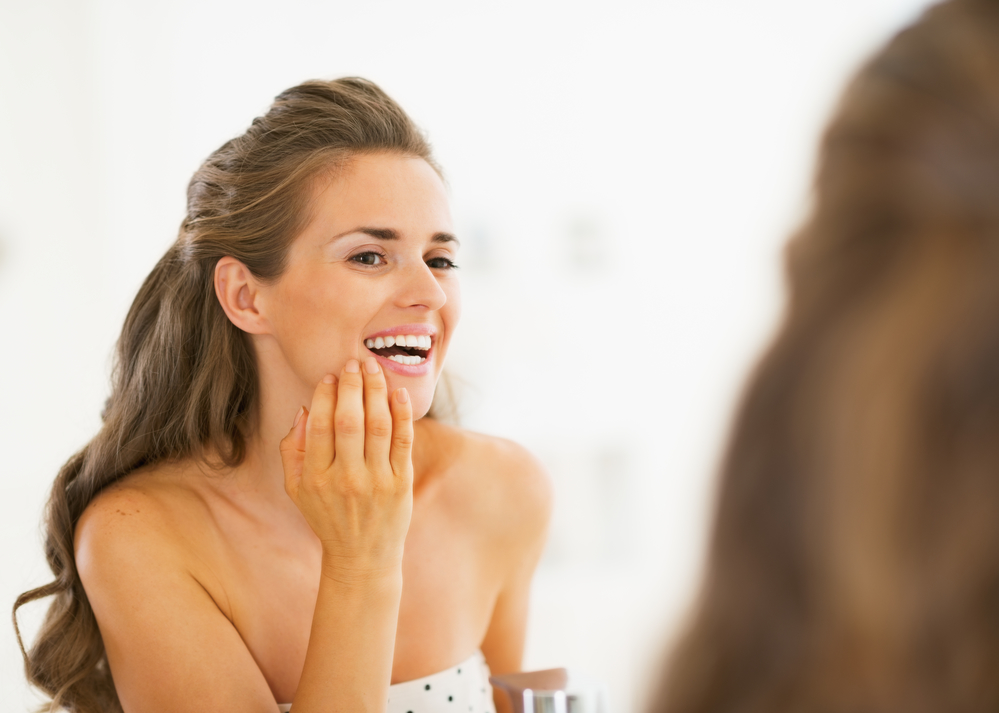 woman checking teeth in the mirror