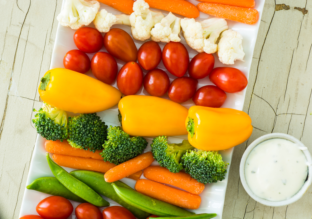 Closeup of vegetable tray with assorted cut vegetables and dip