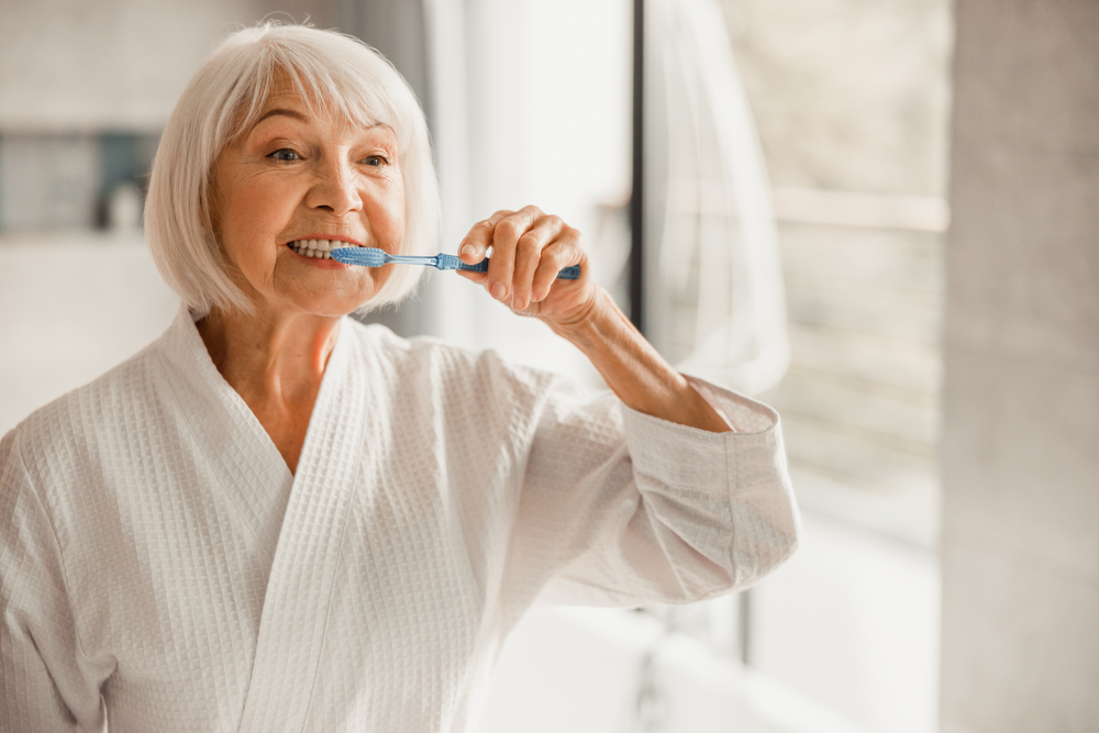 senior woman brushing teeth