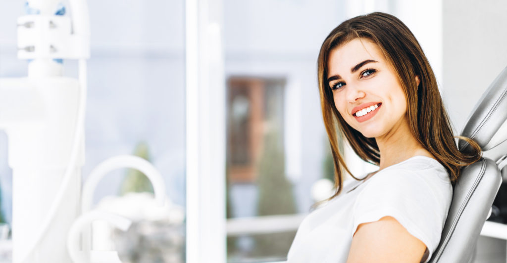 Woman with a healthy smile looking comfortable at the dentist