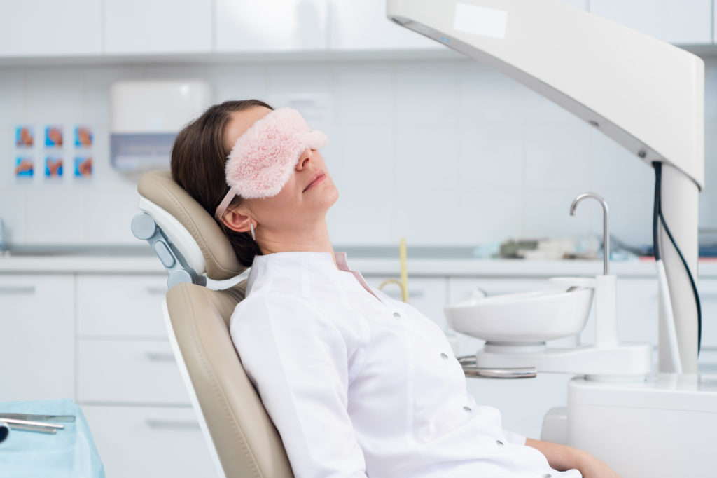 Woman relaxes in dental chair.