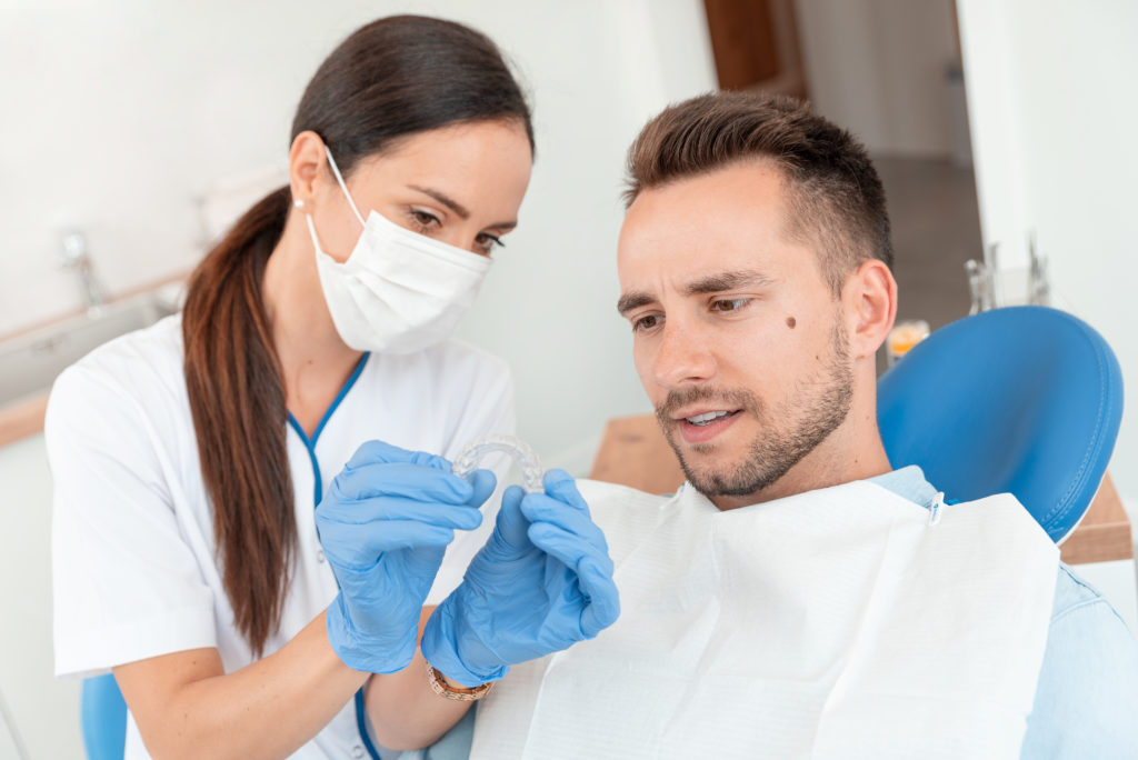 Dentist shows patient the benefits of Invisalign. 