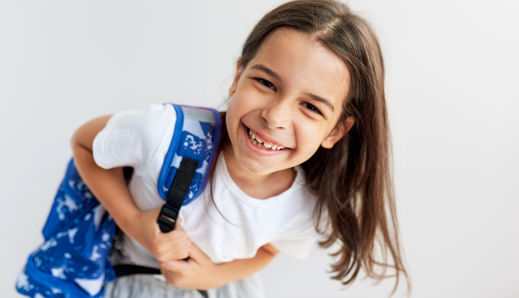 Girl with backpack and healthy smile.