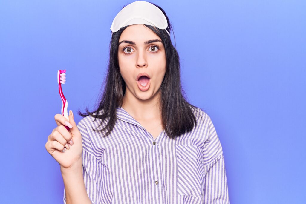Young woman with sleep mask and toothbrush